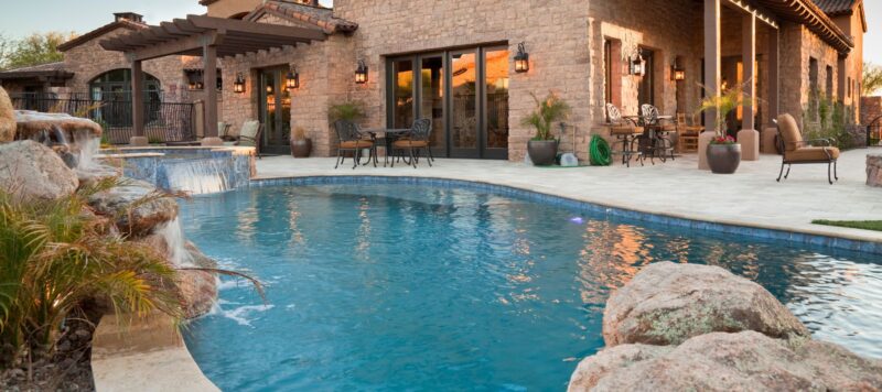 swimming pool in a back yard as the sun sets