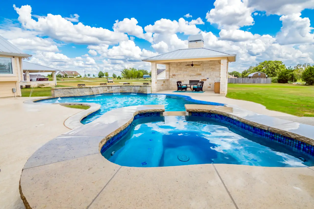 pool with a patio portion in the backyard